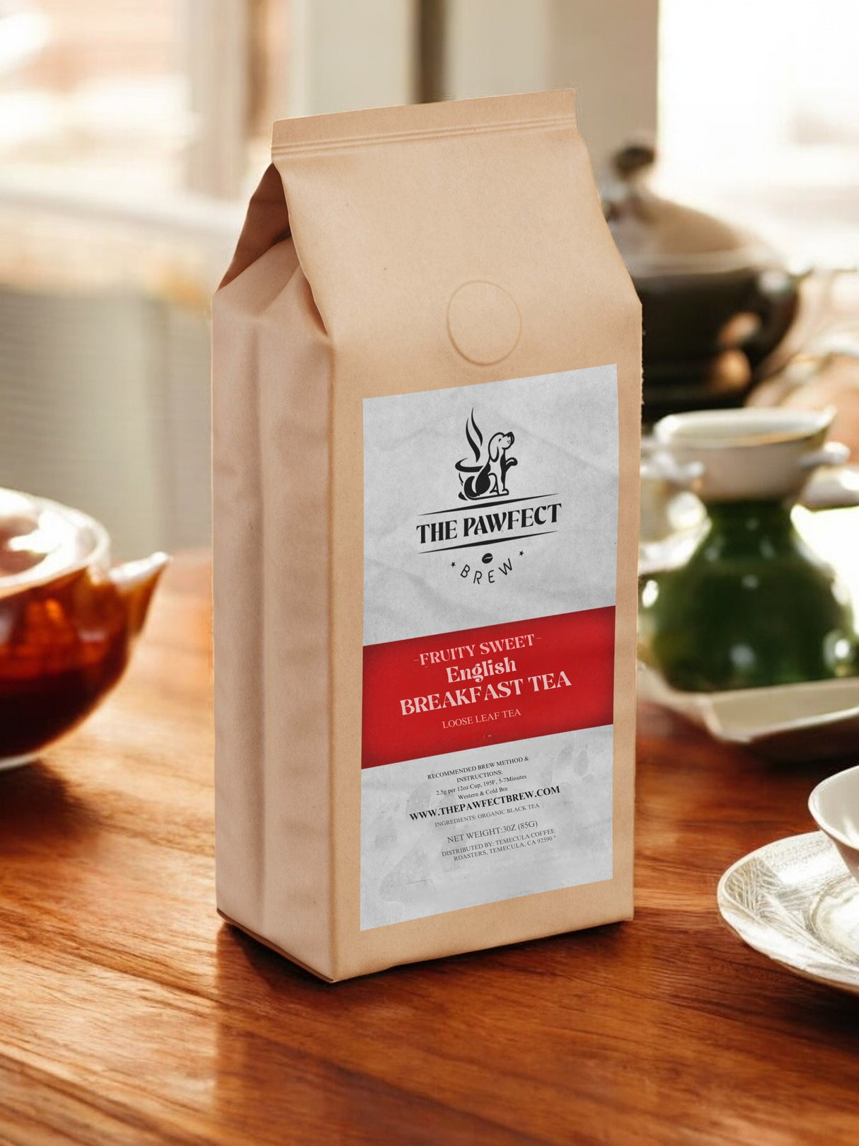 Bag of The Pawfect Brew fruity sweet English Breakfast Tea on a wooden table with teapots in the background.