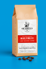 Bali Blue single origin medium dark roast coffee bag with coffee beans on blue background.