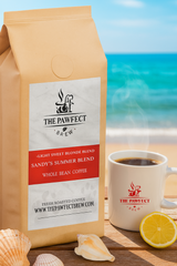 Sandy's Summer Blend light blonde espresso coffee bag with cup at a beach backdrop.